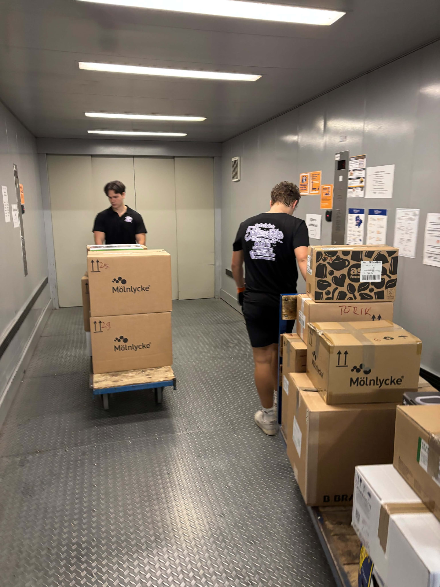 Az 5Star Költöztetés csapata dobozokat szállít egy teherliftben